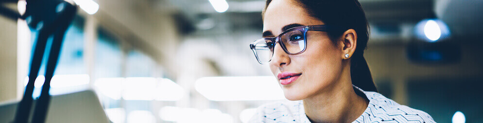 Woman with glasses focusing intently