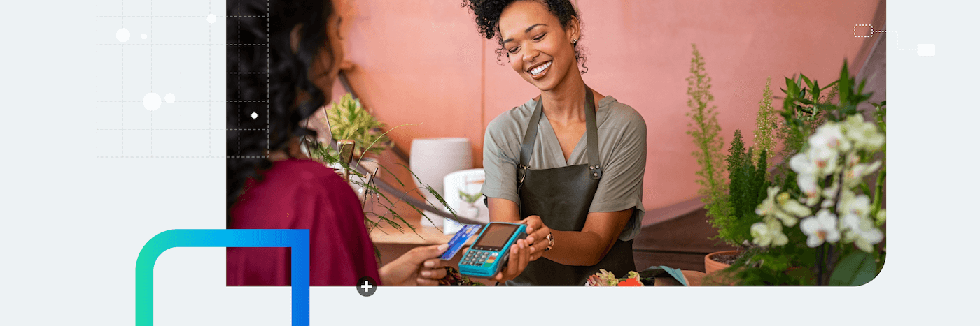 A florist holds a card reader to help a customer check out
