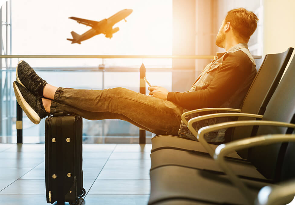 Man sitting in departures watching plane take off