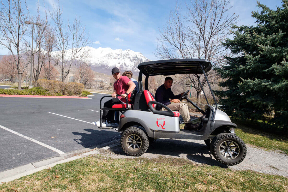 Qualtrics team members head to a local pizzeria via golf cart