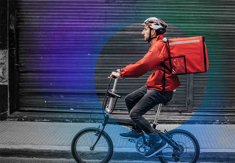 Image of Dominos worker delivering pizza on a bike
