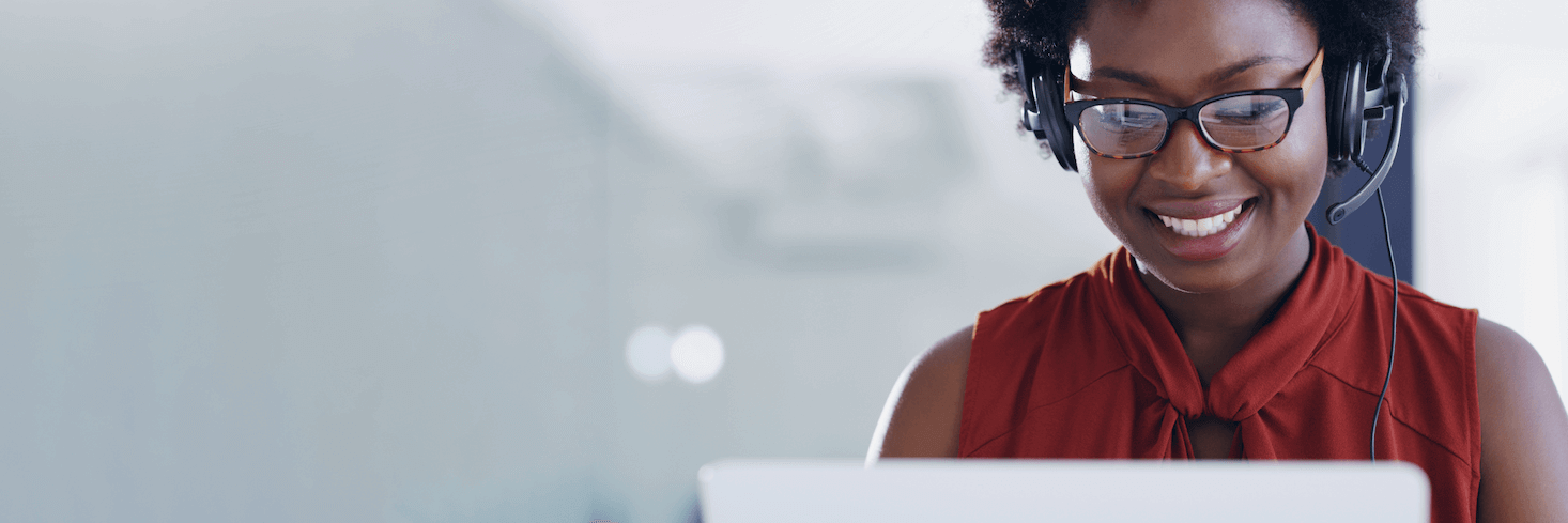 Friendly contact center employee smiling while talking on the phone