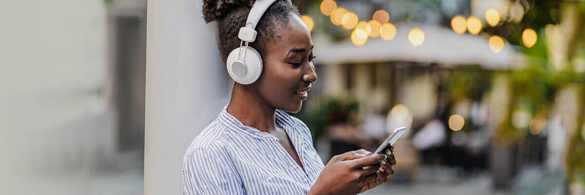 Woman looking at her phone with headphones on