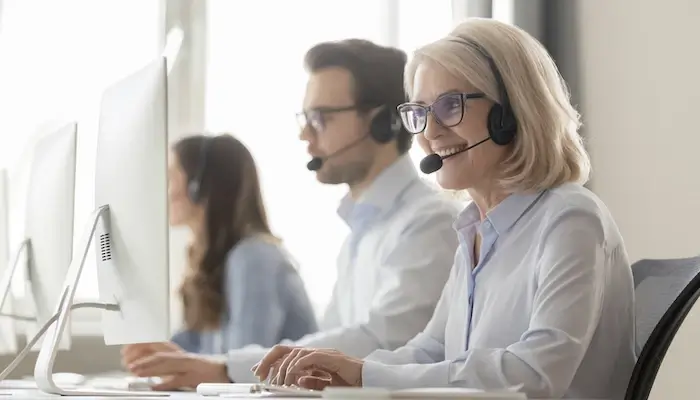 Image of happy looking employee working in contact center environment 