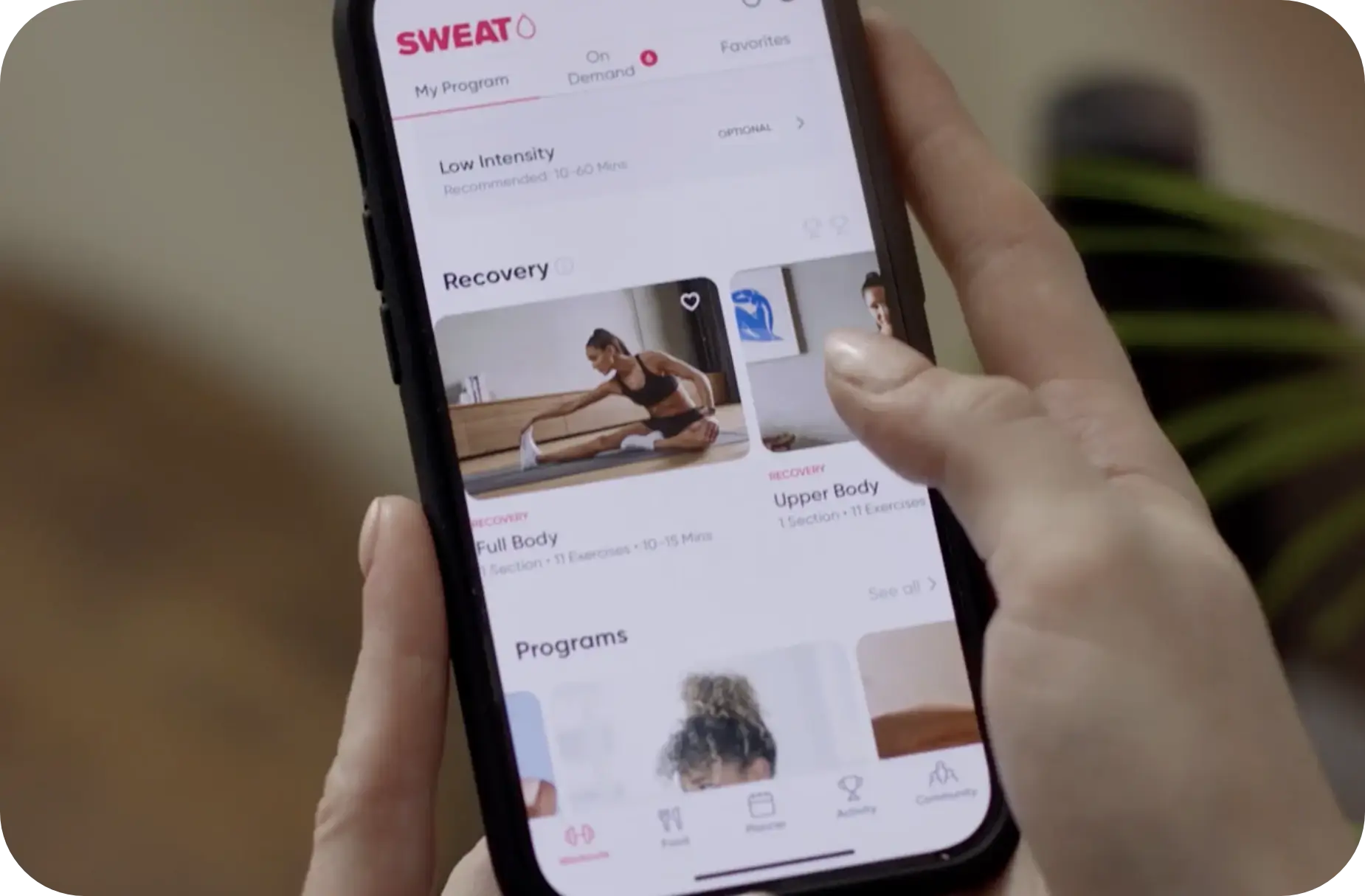 person holding iphone with sweat app