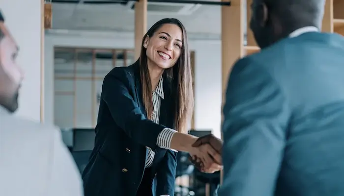 Image of happy looking people wearing business attire and shaking hands