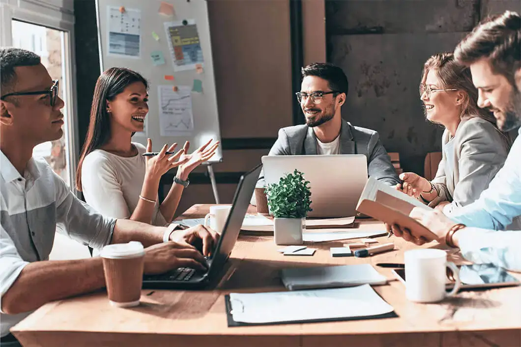 Men and women sitting around a table having a business meeting