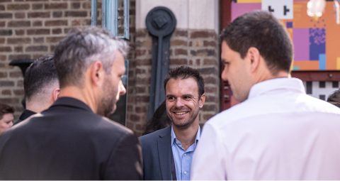 hree professionals networking in conversation at X4 Summit reception event