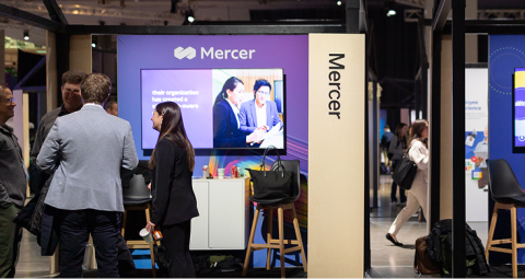 Attendees exploring partner booth with product displays at X4 Summit experience area