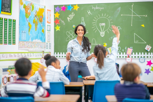 Teacher and young students in classroom.
