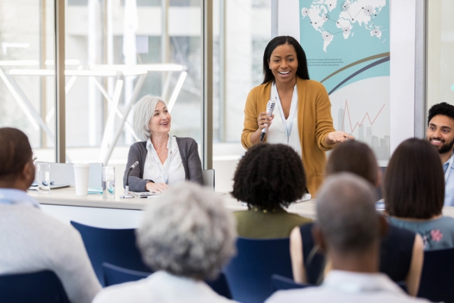 A local, female politician addressing an audience during a panel discussion.