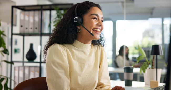 Laughing, happy customer service agent in contact center.