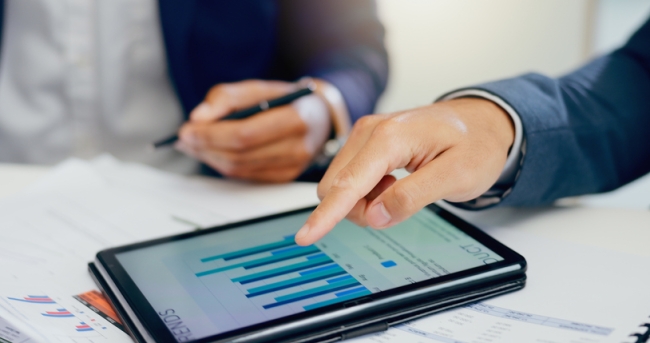 Close up of business people with tablet showing charts from survey data.