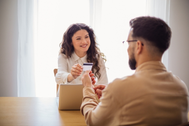 Young couple making online payment using credit card and laptop at home.