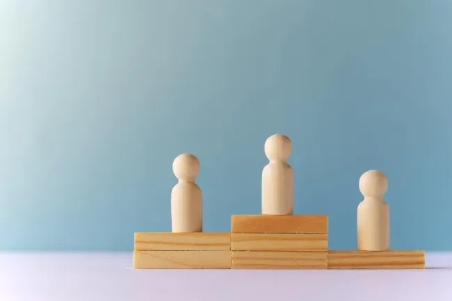 Wooden figures on podiums of different heights