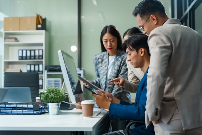Team of professionals reviewing tablet content together in office setting