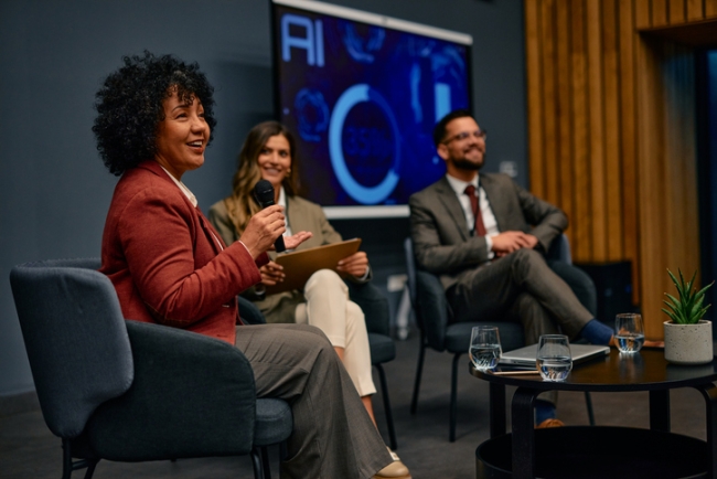 Business panel discussion with professionals engaged in conversation on modern stage setting