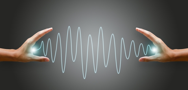 Hands holding glowing sound wave visualization symbolizing audio communication