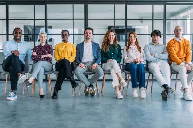 Diverse group of people sitting in a line, smiling