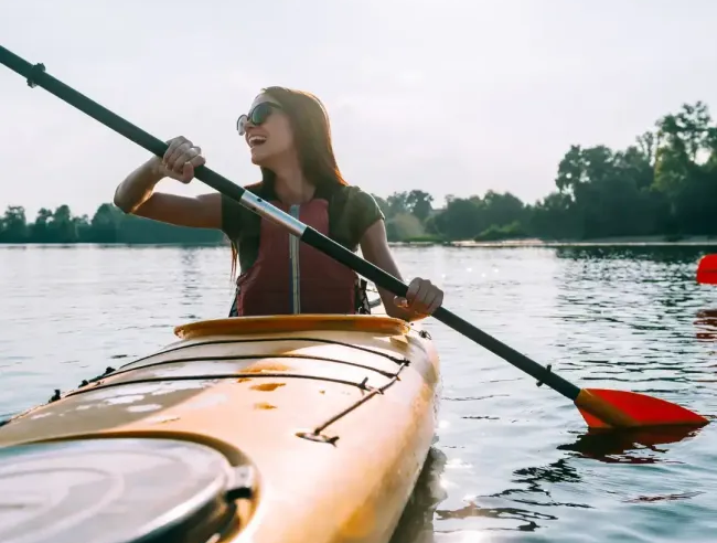 Woman enjoying kayaking in a lake.