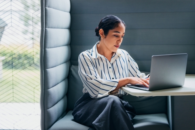A stock image of a woman working at a laptop
