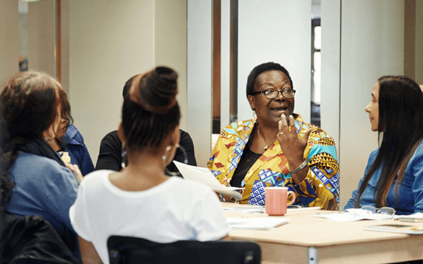 A group of women talking around an office table