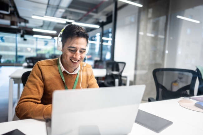 Contact center agent on customer call while looking at laptop.