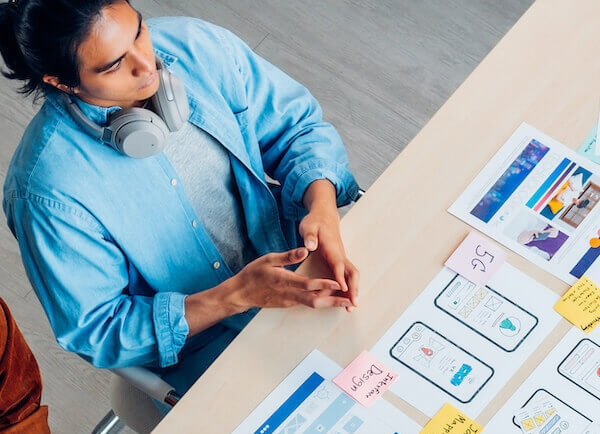 User experience professional examining printed website mock up images for desktop and mobile.