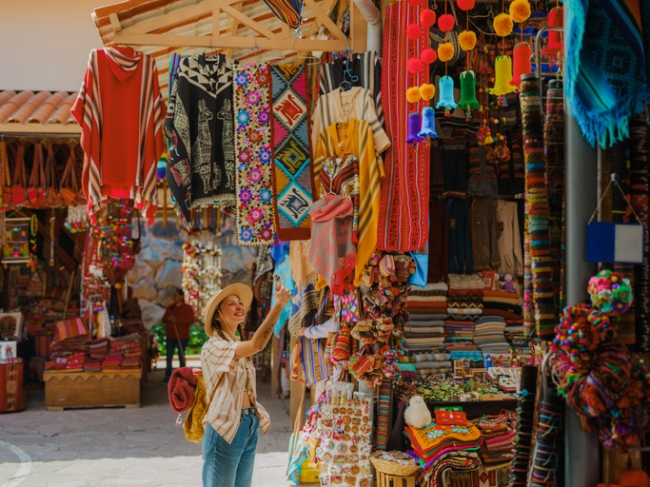 Woman photographing with smartphone on Pisac Market in Peru.