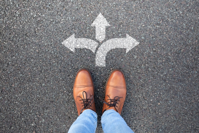 Person standing over 3 arrows pointing in different directions.