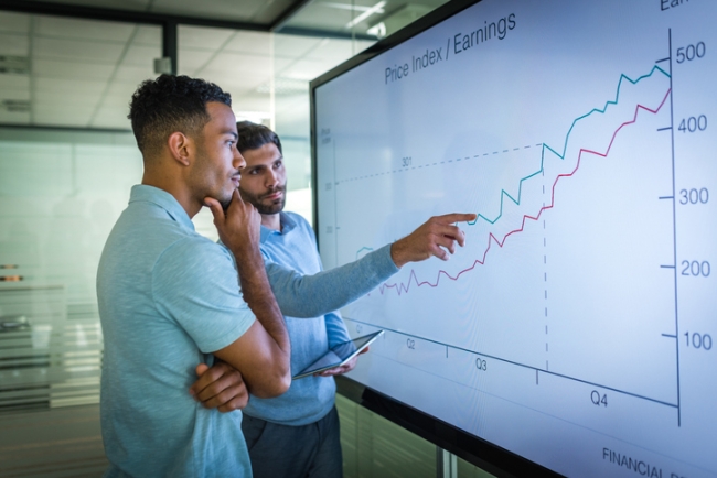 Market research analyst explaining line graph to his manager.
