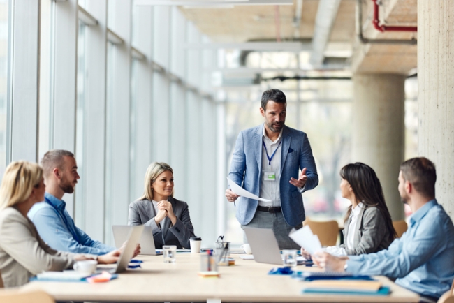 Marketing manager talking to his team about plans at a meeting in the office.