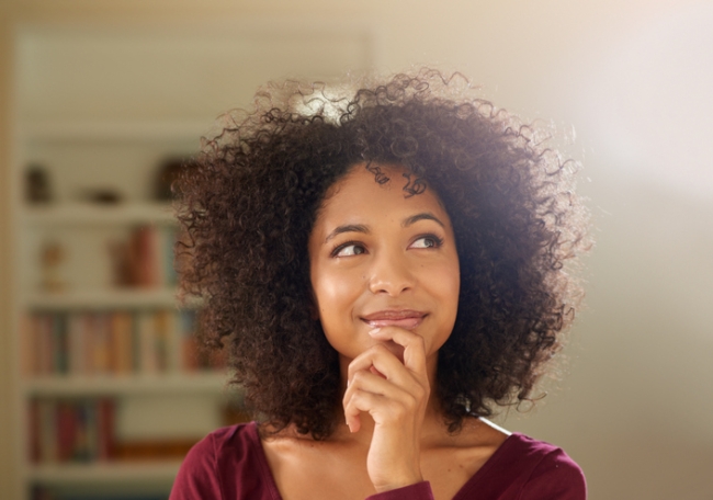 Shot of a insightful-looking young woman at home.