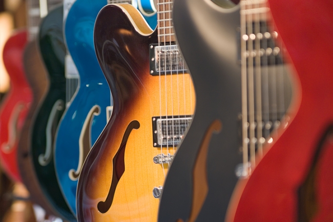 Electric guitars hanging on a rack in a store.