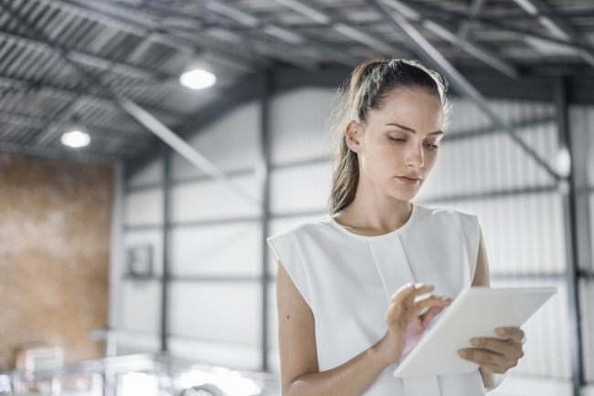 Female worker using digital tablet during QA process at brewery.