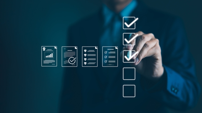 Businessman marking off items on digital checklist, representing quality management and compliance.