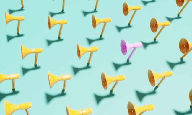 Pink colored megaphone standing out from the crowd.