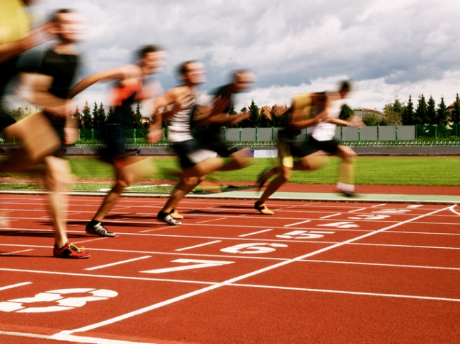 Competitive athletes at the finish line of a close race.