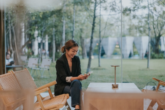 Professional woman checking messages while resting at modern cafe. 