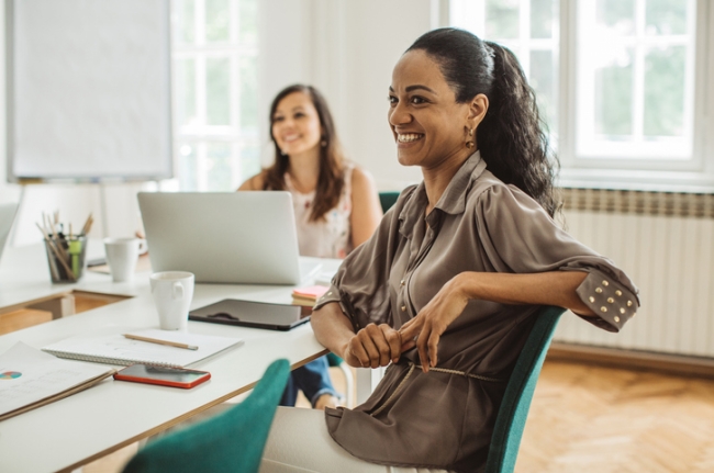 Group of smiling, empowered female employees having a meeting in the office. 