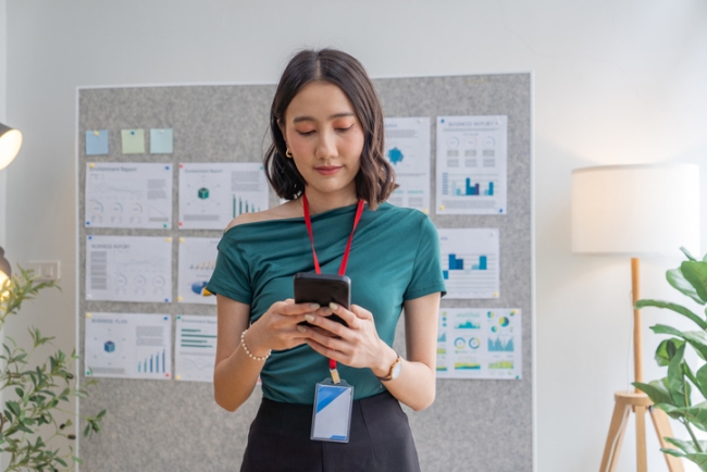 Female employee completing company survey on her smartphone.