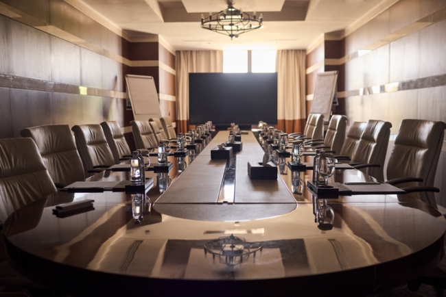 Luxurious boardroom emptied of people, featuring comfortable chairs and prepared for the leadership meeting.