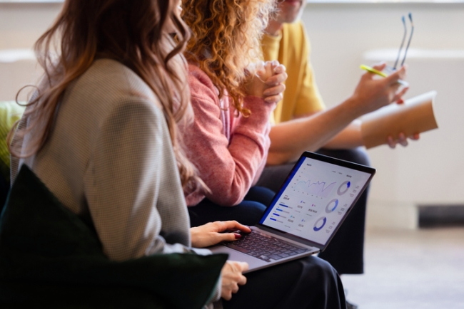 Business team analyzing data on a laptop to reduce customer churn.