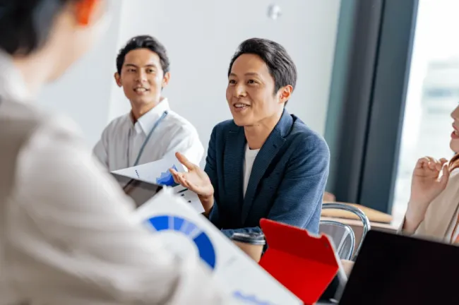 Man talking at office table with peers
