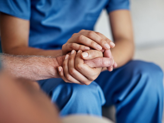 Nurse holding patient's hand