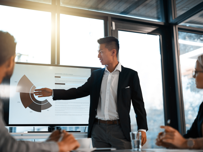 Man points at chart in meeting room