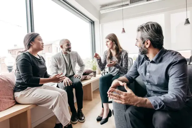 Brand marketing team discussing performance in a casual office setting.