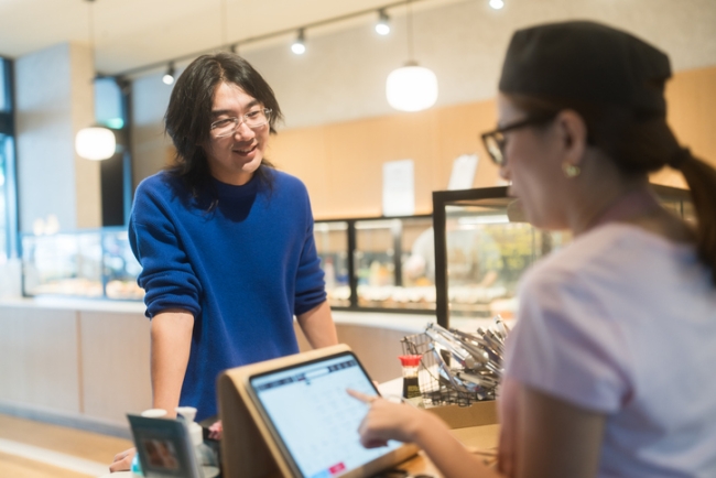 カウンターで客から注文を受け、会計を処理する寿司職人や店員