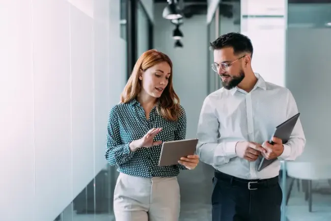 Shot of two coworkers having a discussion in modern office. 