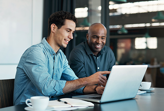 2 customer experience professionals working together at a laptop.